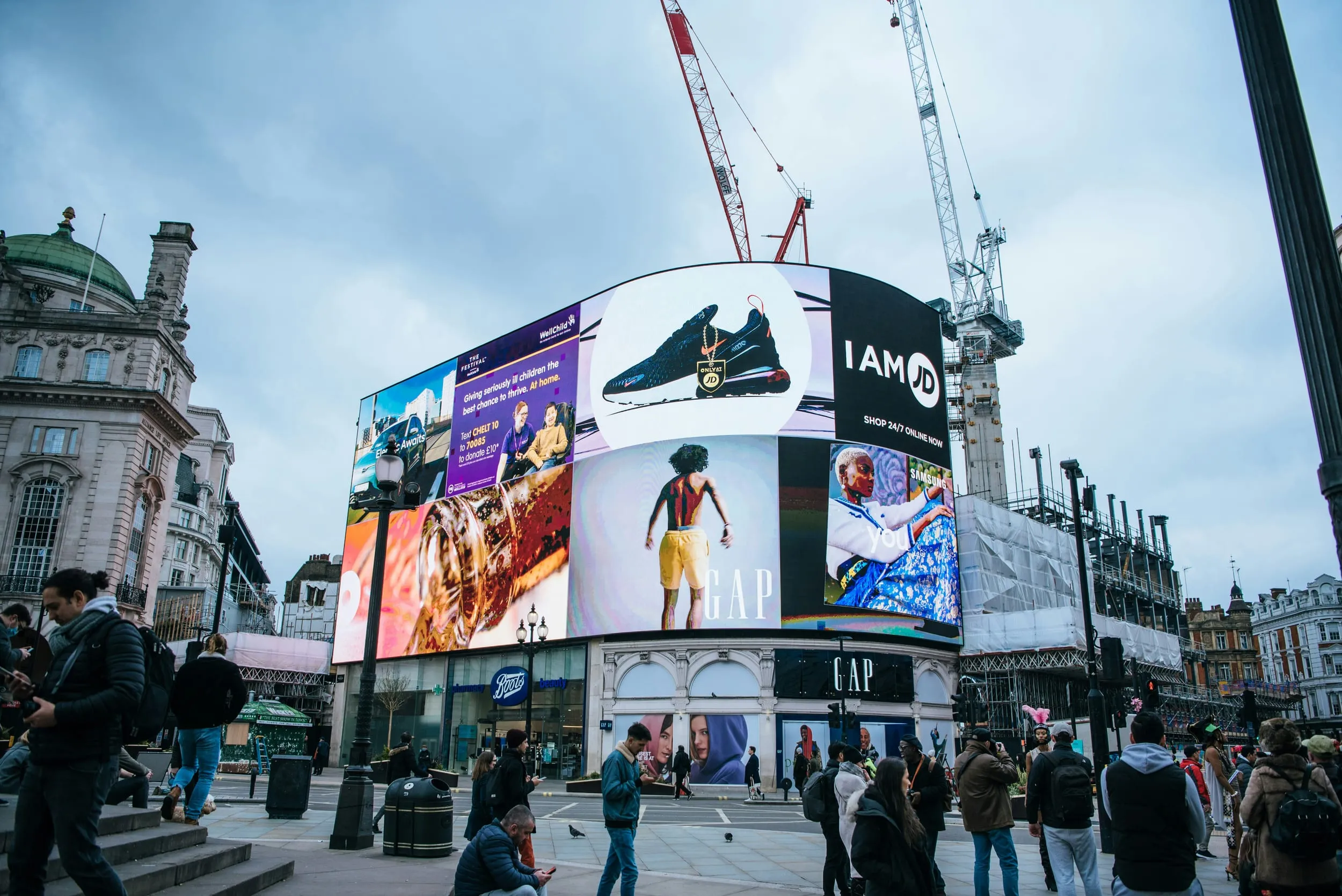 Screens above a crowd at Piccadilly Circus