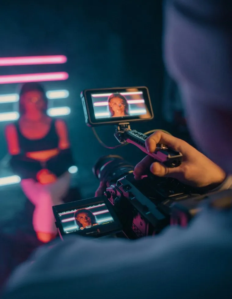 A creator filming under neon light