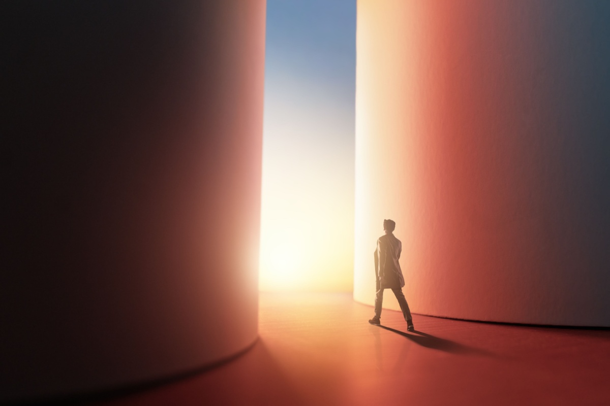 A lone figure walking towards the light between two towering walls, one cool-toned and one warm, evoking the choice between Shopify and WooCommerce for SEO